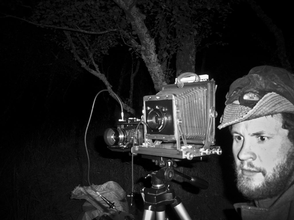 Artist Kenny Martin on location shooting large and medium format simultaneously on the Isle of Skye in Scotland. The midges were terrible - hence the mosquito head net!